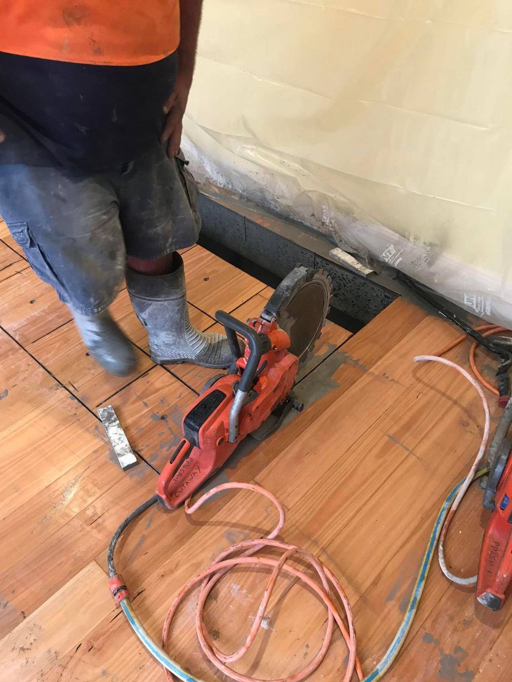 Hand saw finishing cuts through a timber-finished floor